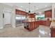 Spacious kitchen with custom wood cabinets, stainless steel appliances, and an island with seating and built in shelving at 104 N Royal Ascot Dr, Las Vegas, NV 89144