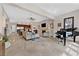 Large living room with fireplace, grand piano, and open layout connecting to the kitchen and dining areas at 104 N Royal Ascot Dr, Las Vegas, NV 89144