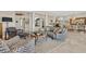 Open-concept living room with gray sofa, patterned chairs, glass coffee table, and access to the dining area at 104 N Royal Ascot Dr, Las Vegas, NV 89144