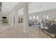 Spacious living room with marble floors, large windows, and views of the outdoor landscape and golf course at 104 N Royal Ascot Dr, Las Vegas, NV 89144