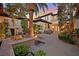 An expansive outdoor patio features a seating area, lush landscaping, and water feature at dusk at 104 N Royal Ascot Dr, Las Vegas, NV 89144
