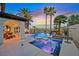 Stunning outdoor pool and spa area with lush landscaping, palm trees, and a covered lounge at 104 N Royal Ascot Dr, Las Vegas, NV 89144