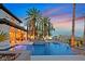 Beautiful outdoor pool with water features surrounded by mature palm trees and manicured landscaping at 104 N Royal Ascot Dr, Las Vegas, NV 89144