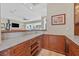 Elegant wet bar with wood cabinetry, shelving, granite countertops, and a view to the living room at 104 N Royal Ascot Dr, Las Vegas, NV 89144