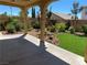 Beautifully landscaped backyard with rock features, synthetic grass, mature trees, and custom patio at 11005 Edina Ct, Las Vegas, NV 89144