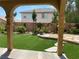 View of the backyard with mature landscaping, synthetic grass, rock accents and outdoor living at 11005 Edina Ct, Las Vegas, NV 89144