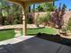 Inviting backyard space featuring artificial turf, stone accents, and lush landscaping at 11005 Edina Ct, Las Vegas, NV 89144