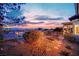Lush backyard featuring desert landscaping, wooden bridge, and a covered patio with city views at 2167 Fairweather St, Henderson, NV 89052