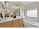 Bright bathroom with double sinks, separate tub, and glass block window offers a tranquil retreat at 2167 Fairweather St, Henderson, NV 89052