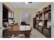 Bright home office with a large wooden desk, ample shelving, natural light, and carpeted floors at 2167 Fairweather St, Henderson, NV 89052