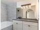Bathroom featuring gray tiled walls, shower, and vanity with great lighting at 2200 S Fort Apache Rd # 2023, Las Vegas, NV 89117