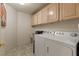 Laundry room features a sink, white washer and dryer and blonde cabinets at 2766 Chokecherry Ave, Henderson, NV 89074
