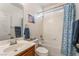 Clean bathroom with a single sink vanity and shower-tub combination accented with blue towels and decor at 2851 Glistening Grove Ave, Henderson, NV 89052
