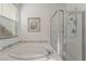 Bathroom featuring a soaking tub with tile accents, shower, and window for natural light at 2851 Glistening Grove Ave, Henderson, NV 89052