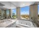 Bright bathroom featuring a soaking tub, dual sinks, and a large window with city views at 322 Karen Ave # 1507, Las Vegas, NV 89109