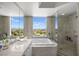 Luxurious bathroom featuring a soaking tub with city views and a separate glass-enclosed shower at 322 Karen Ave # 1507, Las Vegas, NV 89109