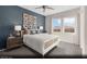 Cozy bedroom with a stylish white bed, blue accent wall, plush carpet, and lots of natural light at 325 Talladega Ct # Lot 6, Henderson, NV 89015