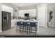 Modern kitchen with white cabinets, stainless steel appliances, an island with seating, and wood-look flooring at 325 Talladega Ct # Lot 6, Henderson, NV 89015