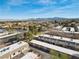 An aerial view of the townhouse complex with garages and lush landscaping with mountain views in the distance at 3365 Zephyr Ct, Las Vegas, NV 89121