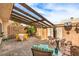 Spacious back patio featuring pavers, pergola, tan siding, a wooden fence, seating, and manicured landscaping at 3365 Zephyr Ct, Las Vegas, NV 89121