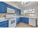Cozy kitchen features blue cabinets, tile backsplash, and a bright window at 3365 Zephyr Ct, Las Vegas, NV 89121