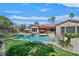 Backyard featuring a pool, grass, palm trees, and inviting lounge areas at 337 Glenridding St, Las Vegas, NV 89183