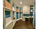 Walk-in closet complete with custom shelving, cabinets, a mini fridge, desk space, and hardwood flooring at 337 Glenridding St, Las Vegas, NV 89183