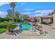 Private pool surrounded by lush landscaping, a red umbrella, and lounge chairs at 337 Glenridding St, Las Vegas, NV 89183