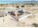 Aerial view showcases a desert home with a pool, solar panels, fenced yard, and a detached garage, ideal for desert living at 3424 Mount Charleston Dr, Pahrump, NV 89048