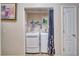 Compact laundry area featuring a white washer and dryer setup, shelving for storage, and a doorway for easy access at 3424 Mount Charleston Dr, Pahrump, NV 89048