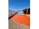 Private backyard swimming pool with a unique red concrete deck and a chain-link fence at 3424 Mount Charleston Dr, Pahrump, NV 89048