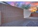 Private backyard space showcasing block fence, desert landscaping, and colorful sunset backdrop at 393 Desert Cadence St, Henderson, NV 89011