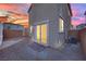 Cozy backyard with a view of the home's back entrance and desert landscaping at 393 Desert Cadence St, Henderson, NV 89011