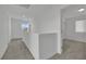 Upstairs hallway with gray carpet and view to bedroom with natural light at 393 Desert Cadence St, Henderson, NV 89011