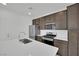 Modern kitchen with stainless steel appliances, white countertops, and dark brown cabinets at 393 Desert Cadence St, Henderson, NV 89011