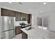 Modern kitchen with stainless steel appliances, a central island, and ample cabinet space at 393 Desert Cadence St, Henderson, NV 89011