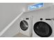 Laundry area equipped with modern washer and dryer, bright lighting, and shelf for optimal functionality at 393 Desert Cadence St, Henderson, NV 89011