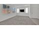 Bright living room with plush carpet, large windows, and a wall-mounted TV at 393 Desert Cadence St, Henderson, NV 89011