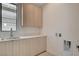 Functional laundry room with ample cabinet space, sink, and connections for a washer and dryer at 3980 Heron Fairway Dr, Las Vegas, NV 89141