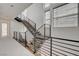 Open staircase with wood treads, black metal railing, and natural light from large windows at 3980 Heron Fairway Dr, Las Vegas, NV 89141