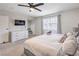 Bright bedroom features a ceiling fan, a TV, and a window providing natural light at 3991 Shadow Wood Ave, Las Vegas, NV 89121