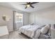 Bright bedroom features a ceiling fan, a large window, and mirrored closet doors at 3991 Shadow Wood Ave, Las Vegas, NV 89121