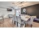 Open dining area with modern light fixture and a view of the fireplace and backyard at 3991 Shadow Wood Ave, Las Vegas, NV 89121