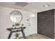 Entryway with wood-look floors, brick accent wall, entry table, and round mirror at 3991 Shadow Wood Ave, Las Vegas, NV 89121