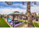 Backyard gazebo with cushioned seating area and view of the pool and covered patio at 3991 Shadow Wood Ave, Las Vegas, NV 89121