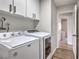 Well-equipped laundry room with a washer, dryer, and overhead cabinets for storage at 3991 Shadow Wood Ave, Las Vegas, NV 89121