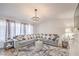 Bright living room featuring a comfortable sofa, stylish rug, and elegant lighting fixture at 3991 Shadow Wood Ave, Las Vegas, NV 89121