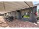 Covered brick patio includes dining table and chairs and entrance to home at 3991 Shadow Wood Ave, Las Vegas, NV 89121