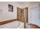Bathroom showcasing a soaking tub and a separate shower with granite surround at 4129 Fabulous Finches Ave, North Las Vegas, NV 89084
