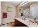 Bathroom featuring double sinks, wood cabinets, and a tub-shower with decorative curtain at 4129 Fabulous Finches Ave, North Las Vegas, NV 89084